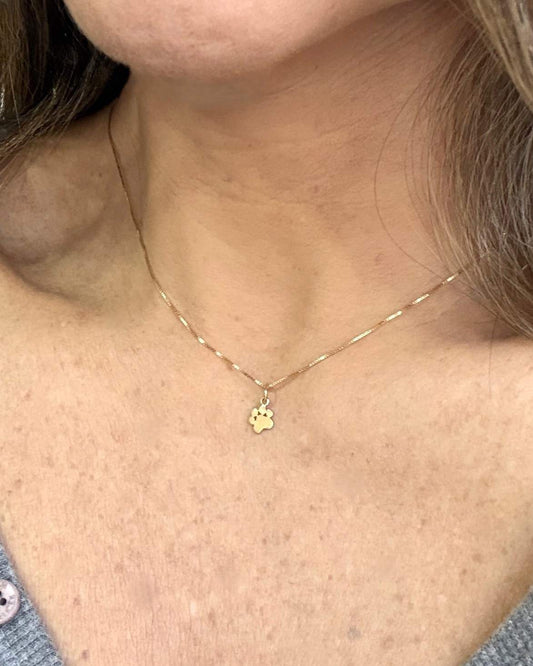 Mulher sutilmente de lado usando Colar Patinha preenchida ouro 18k