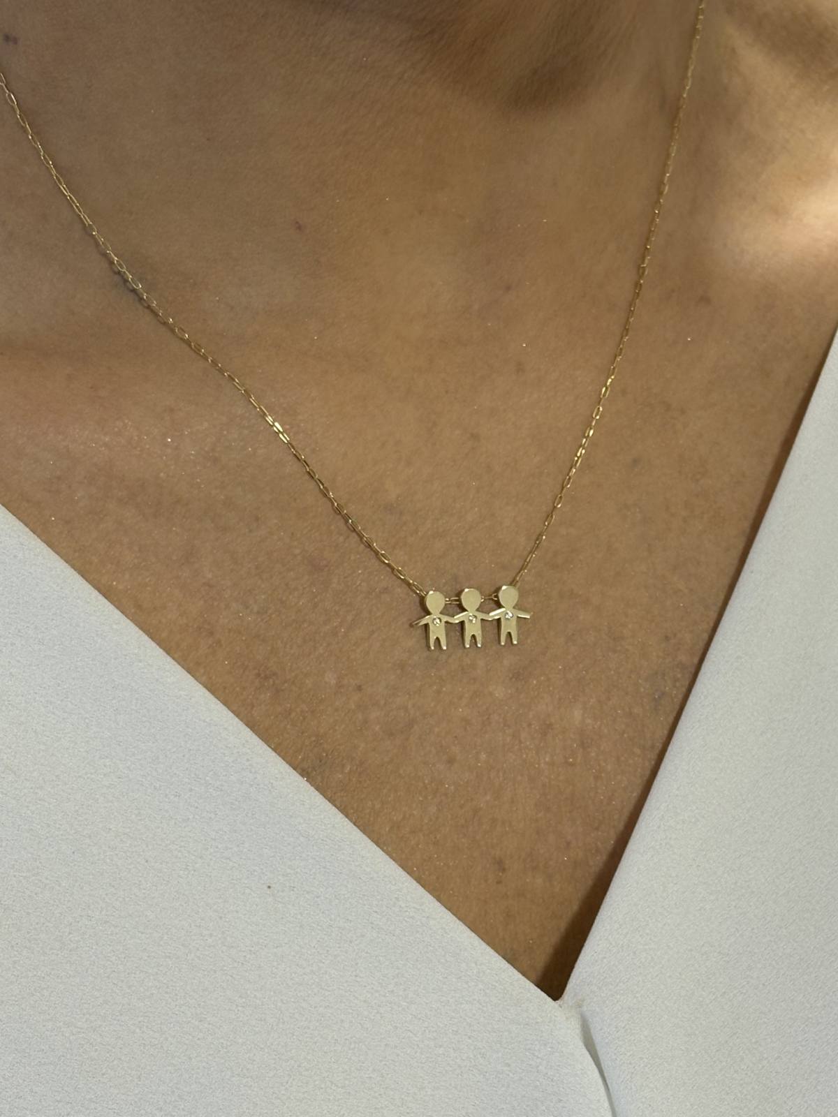 Close no colo da mulher de 43 anos com blusa branca usando um Colar de corrente cartier com 3 filhos com 1cm de altura com brilhantes em ouro 18k