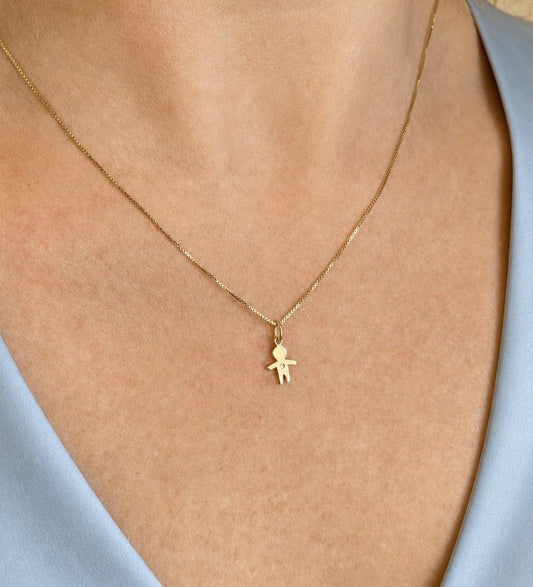 Mulher de 40 anos usando colar com Pingente menino ouro 18k com 1 brilhante de meio ponto