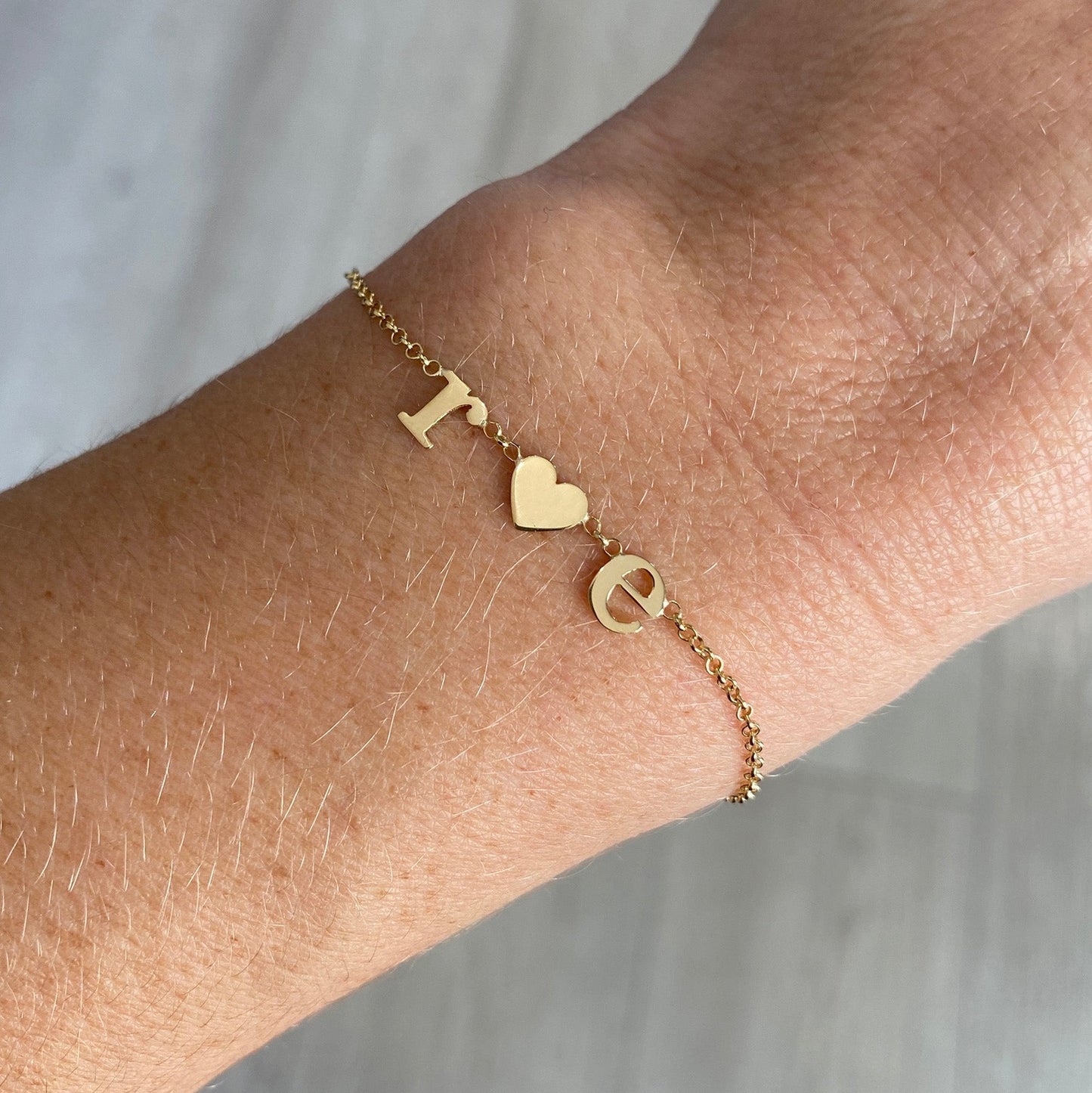 Pulseira de Ouro 18k Letras e Coração no pulso