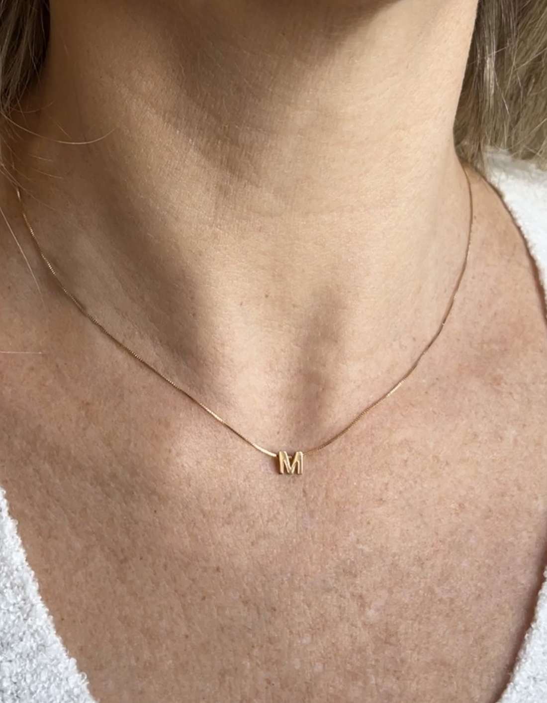 Colar Letra Central Ouro 18k no colo feminino