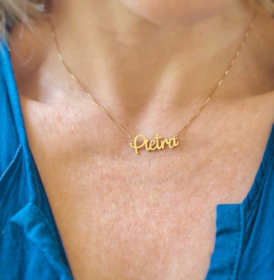 Close no colo de mulher usando um Colar de ouro 18k Nome Grande Pietra na corrente veneziana 0,6mm.