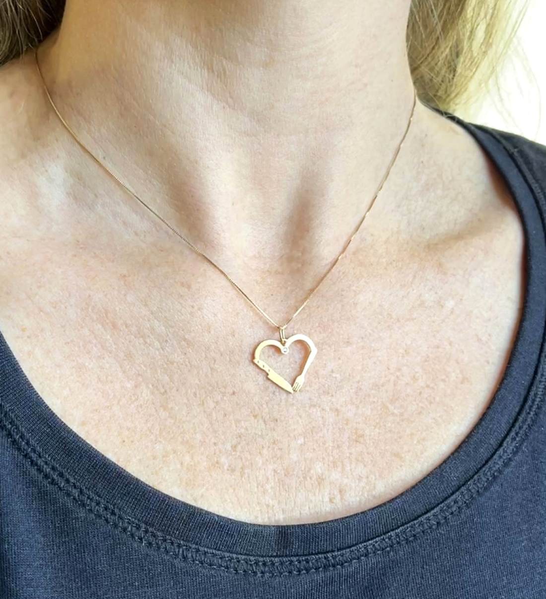 Mulher de 37 anos e blusa azul usando Colar Nutrição Coração Ouro 18k