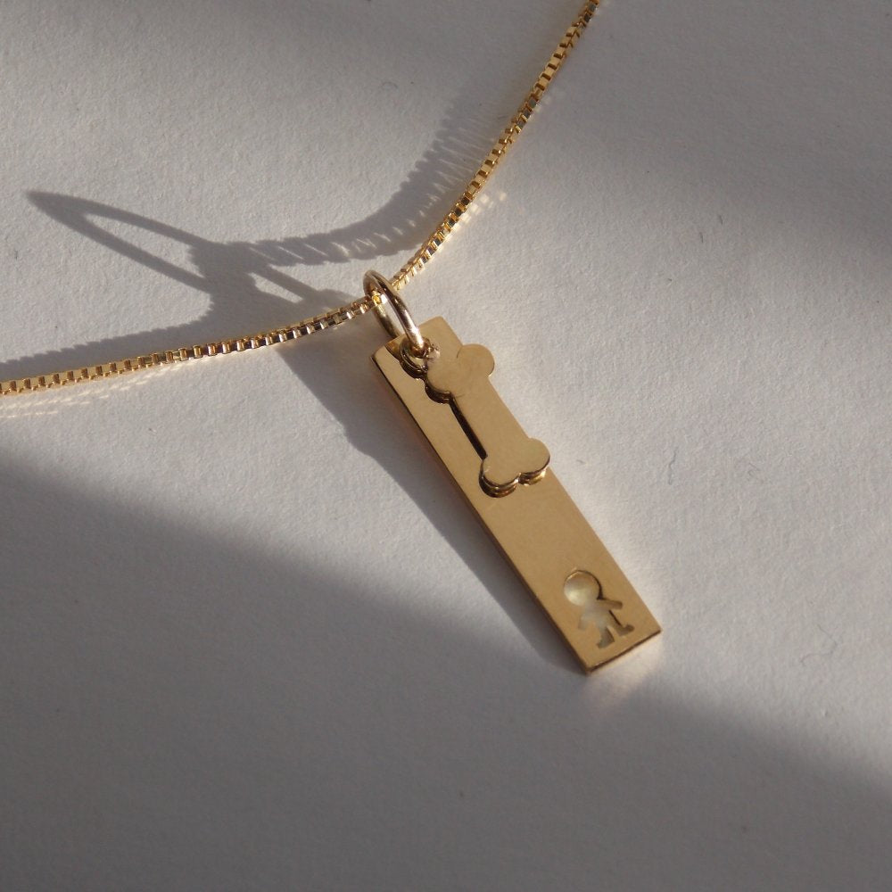 Colar Placa Menino Osso Ouro 18k entre luz e sombra