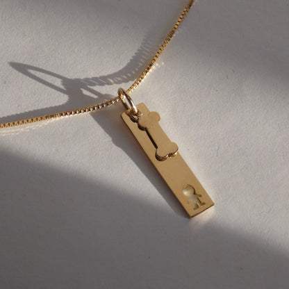 Colar Placa Menino Osso Ouro 18k entre luz e sombra