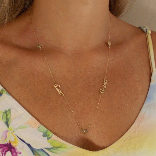Colar de ouro com 2 nomes e 3 corações no colo
