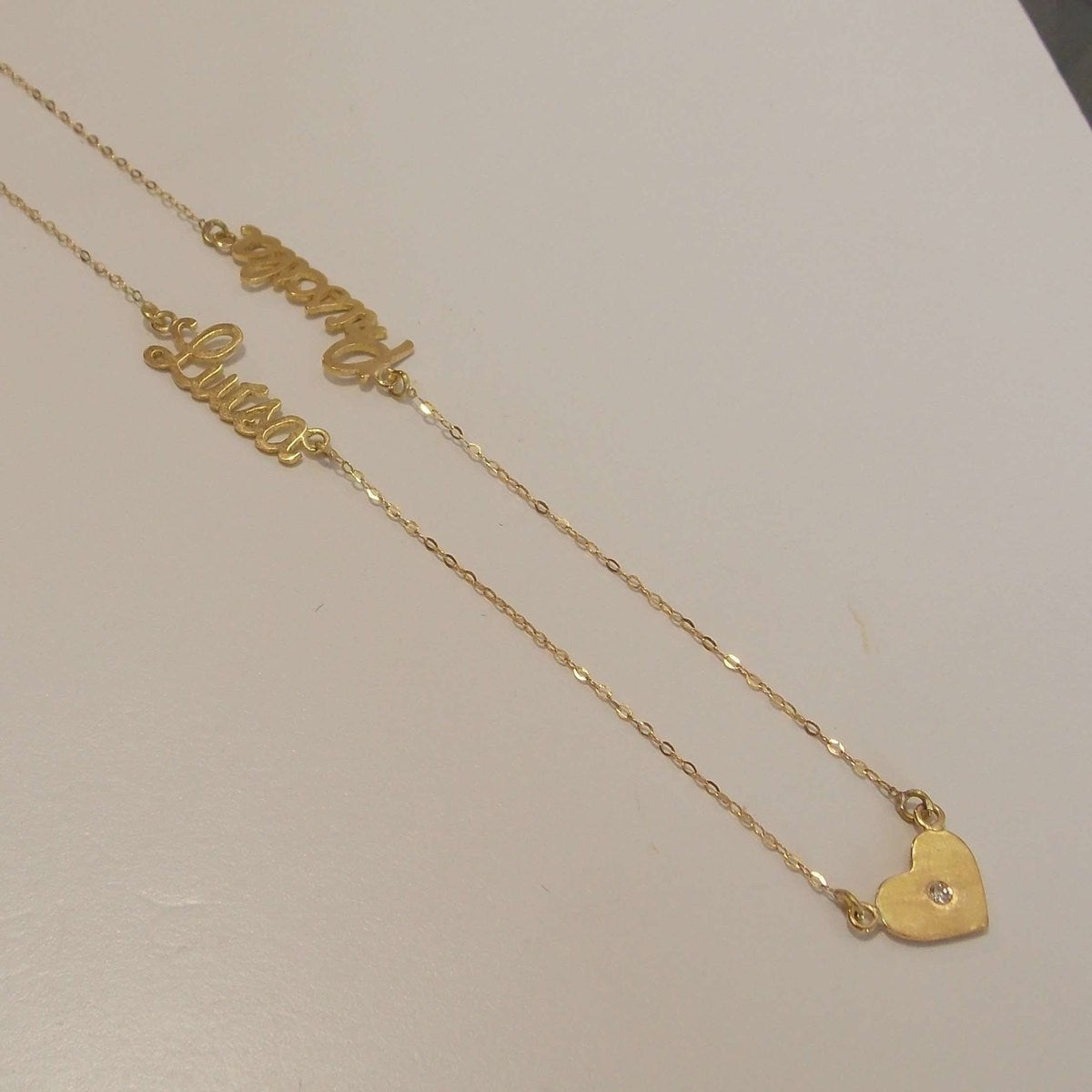 Colar de ouro com 2 nomes e 3 corações em fundo still