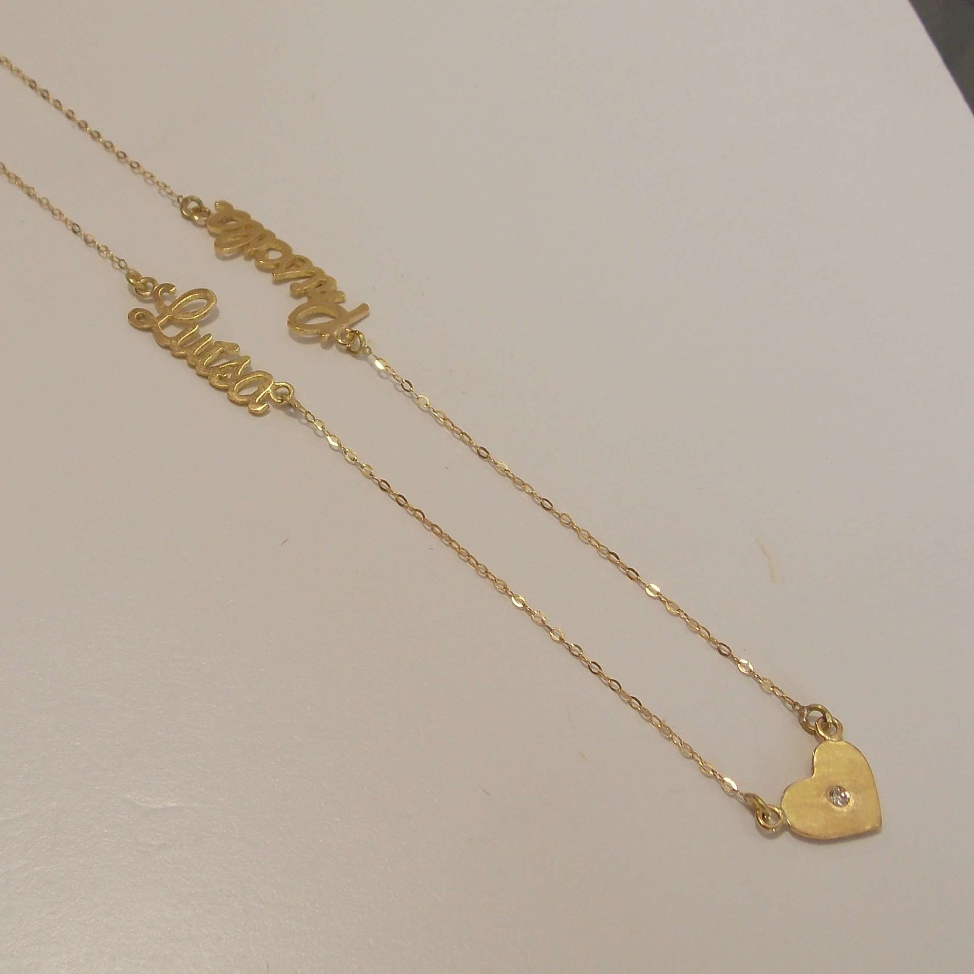 Colar de ouro com 2 nomes e 3 corações em fundo still