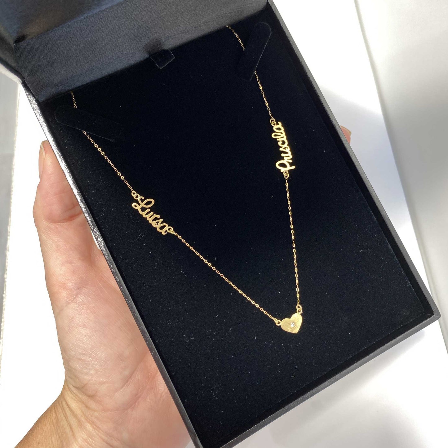 Colar de ouro com 2 nomes e 3 corações no estojo de joia
