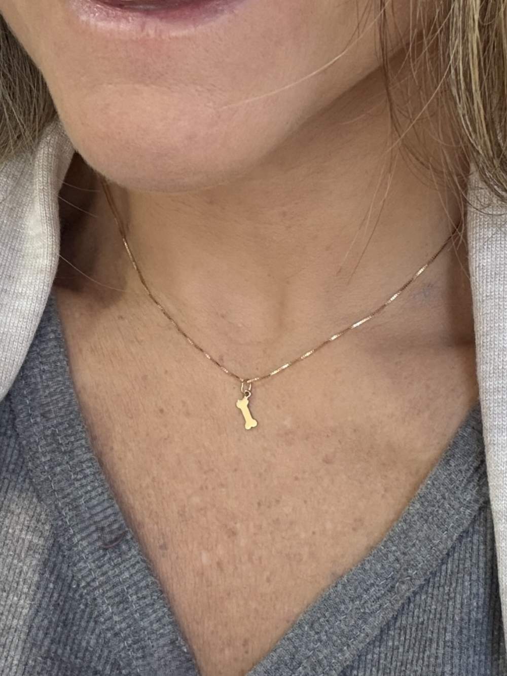Mulher usando Colar ossinho Ouro 18k 