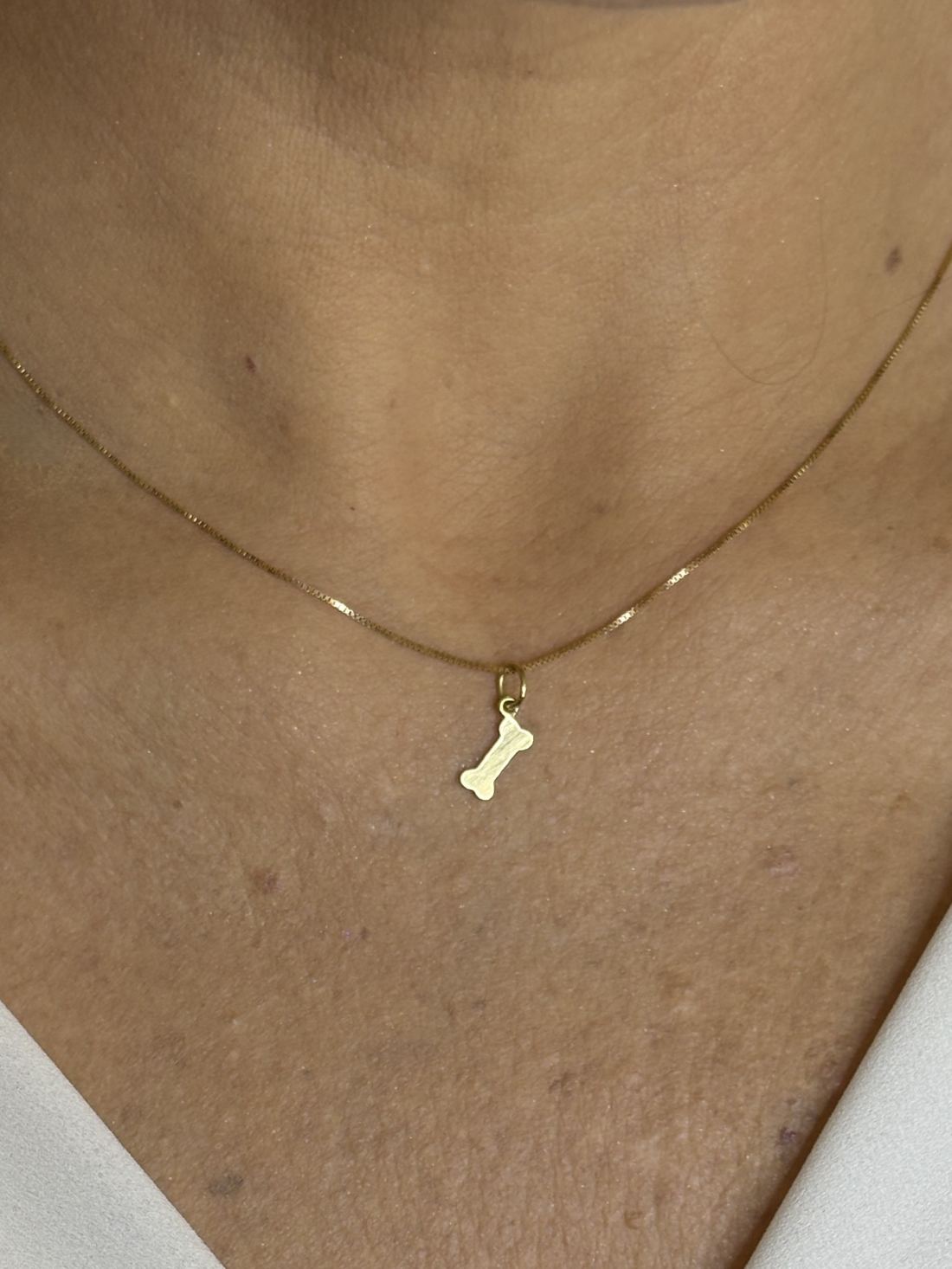 Close no colo da mulher de 44 anos usando Colar com pingente ossinho Ouro 18k 