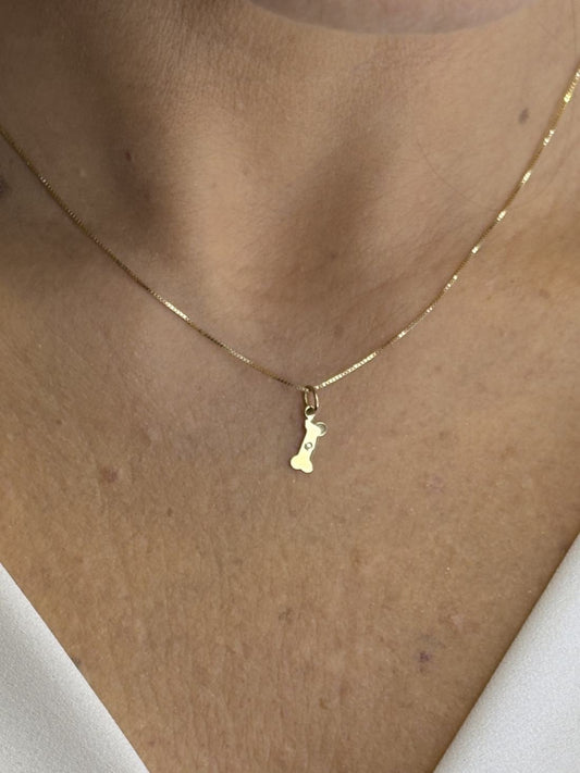 Close no colo da mulher de 44 anos usando Colar com pingente ossinho com diamante em Ouro 18k 