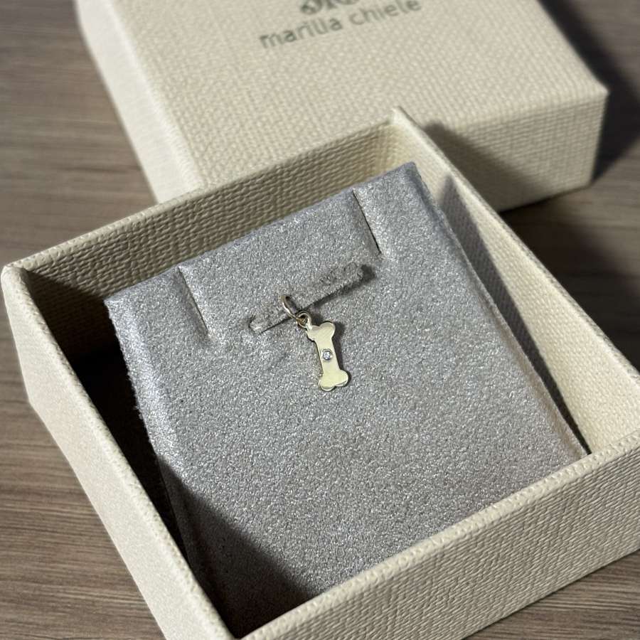 Pingente ossinho com diamante em Ouro 18k na embalagem de joia marilia chiele
