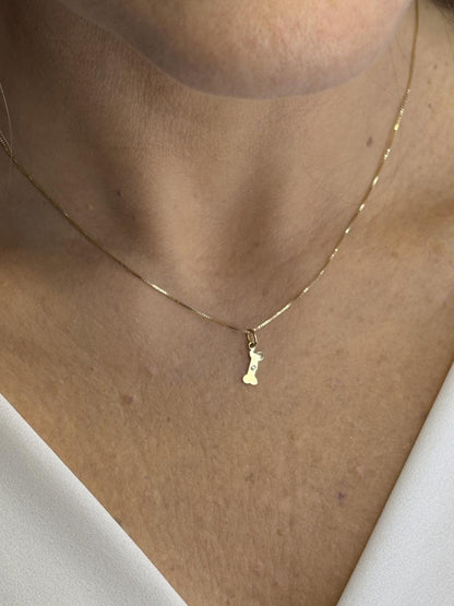 Mulher de 44 anos usando Colar com pingente ossinho com diamante em Ouro 18k 