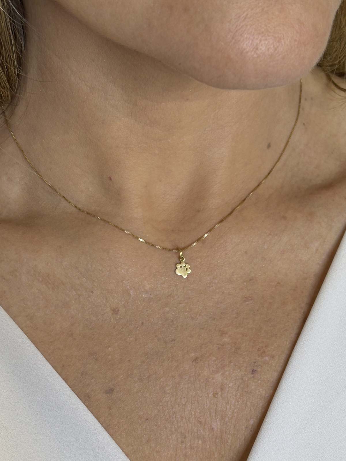 Close na Mulher usando Colar Patinha ouro 18k