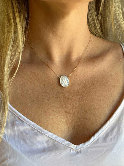 Mulher de cabelo loiro e blusa branca usando Colar São Jorge Camafeu Ouro 18k