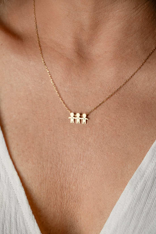Close no colo da mulher de 44 anos com blusa branca usando um Colar de corrente cartier com 3 filhos com brilhantes em ouro 18k