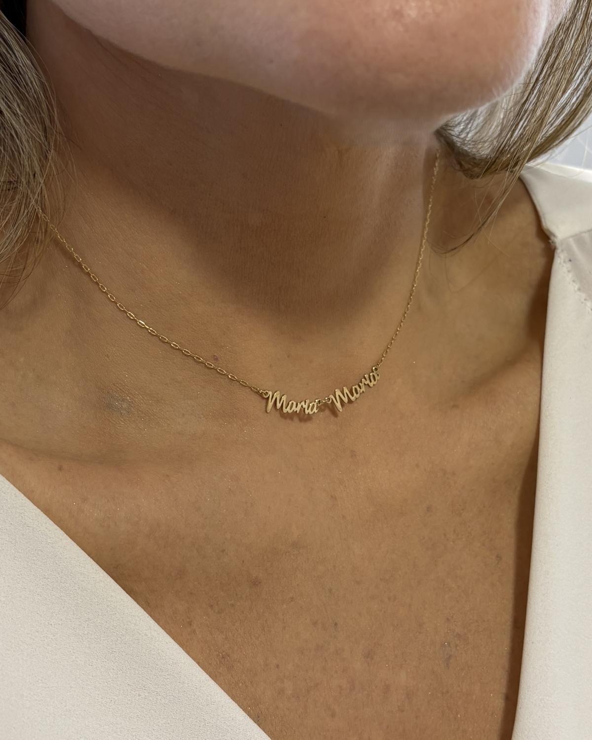 Mulher com blusa branca gola v usando colar de ouro 18k corrente cartier com nome composto personalizado Maria Maria