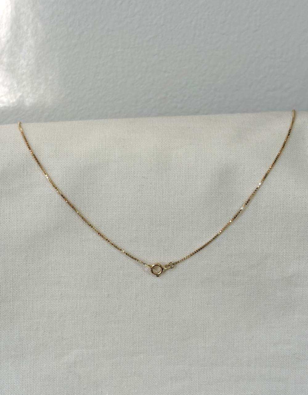 Corrente veneziana 0,7mm ouro 18k apoiada em tecido linho 