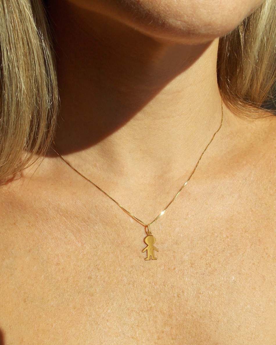 Mulher usando colar com Pingente Menino Ouro 18k