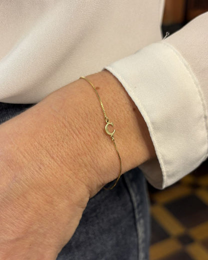 pulseira ouro 18k letra no pulso feminino