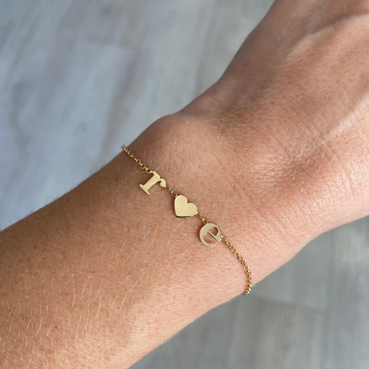 Pulseira de Ouro 18k Letras e Coração no pulso