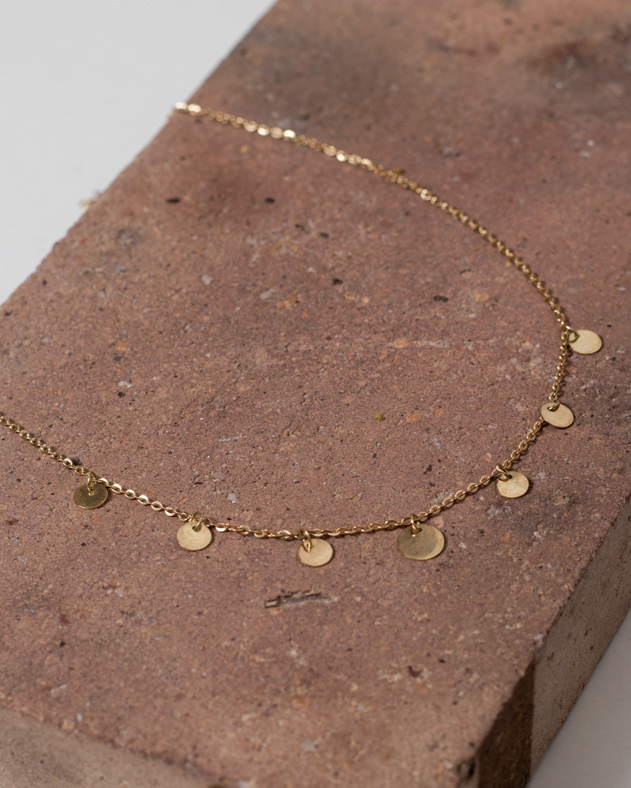 Colar ouro 18k corrente bailarina e medalhas apoiado na pedra