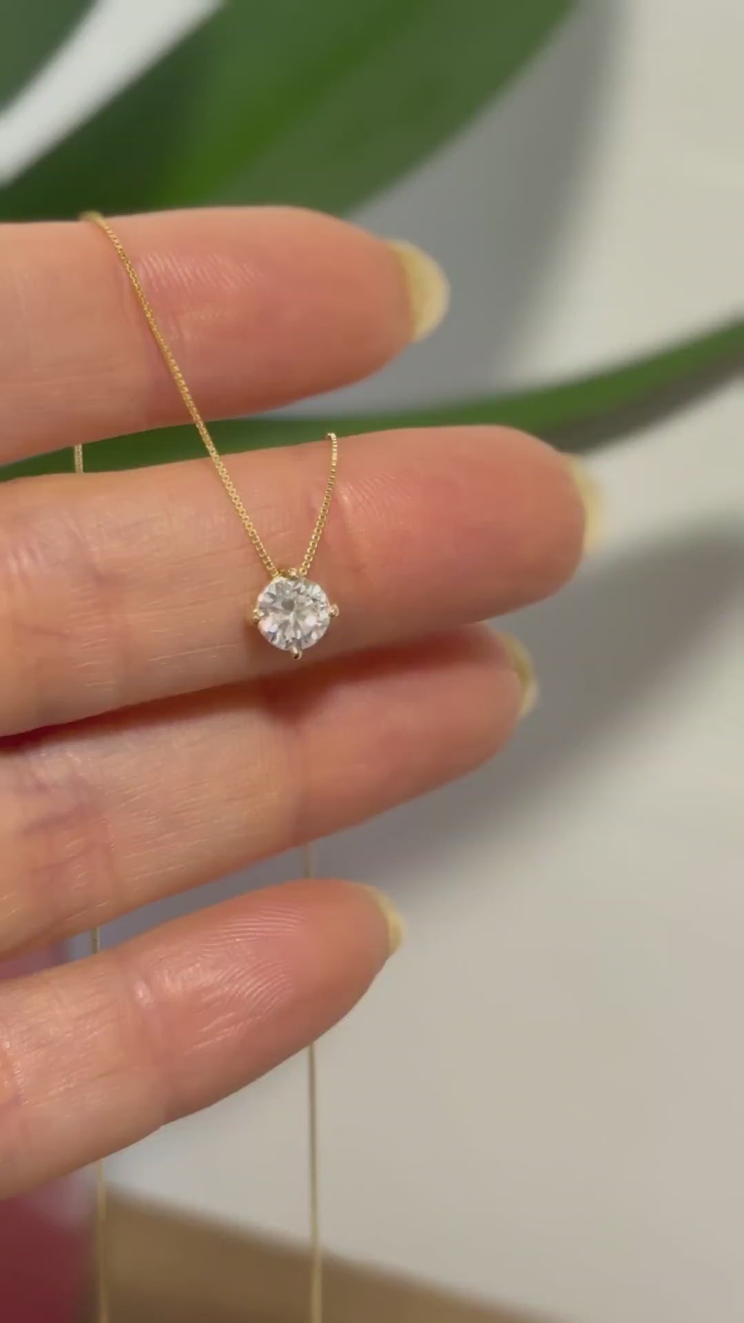 colar Ponto de Luz Moissanite de 5mm Ouro 18k da Marilia Chiele Joias sendo manuseado na mão feminina